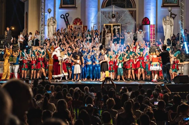 Espetáculo natalino do Encanta Marau em frente à Igreja Matriz, com público lotado
